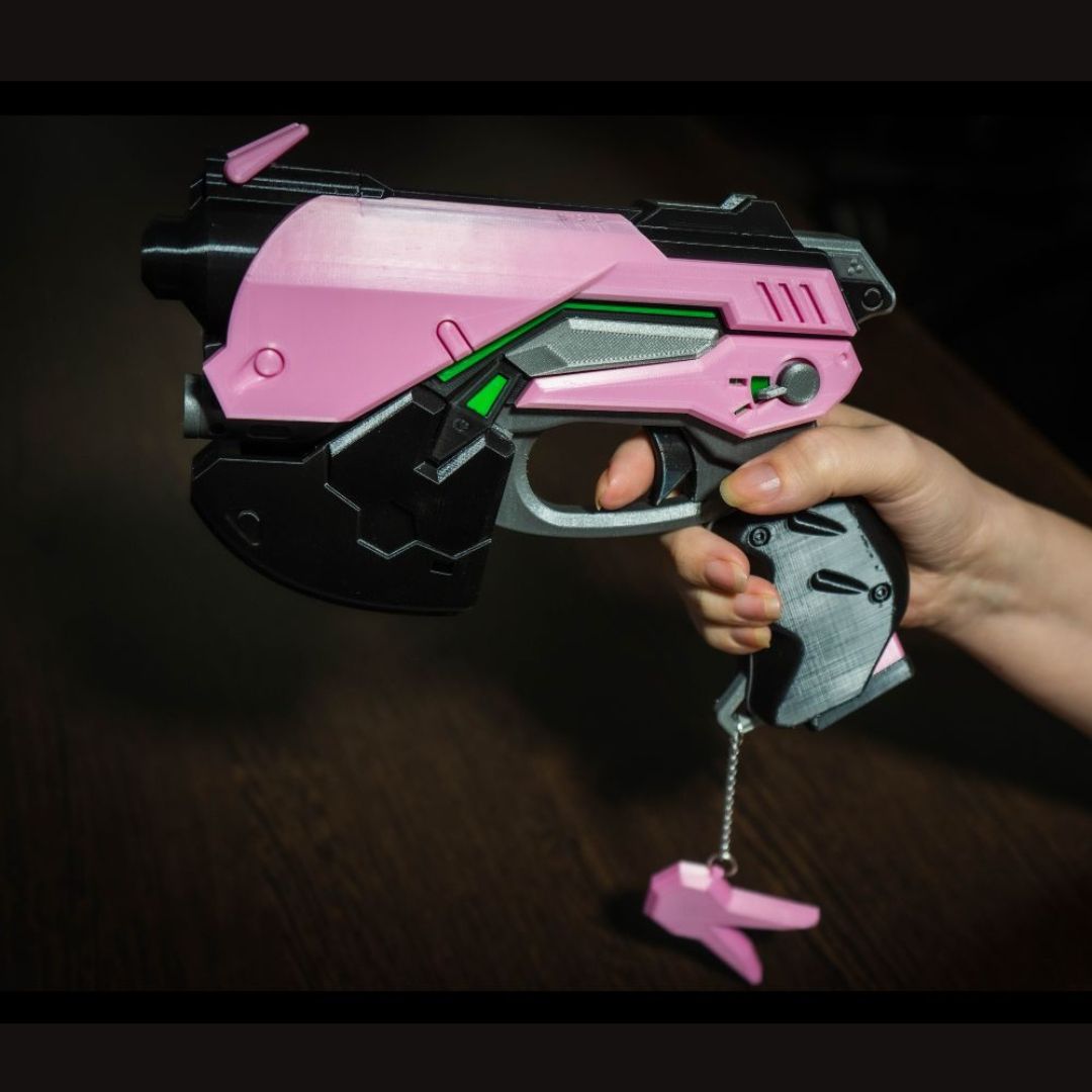 Handheld pink and black D.Va cosplay gun replica prop pistol with green accents, detailed and lightweight for video game cosplay.