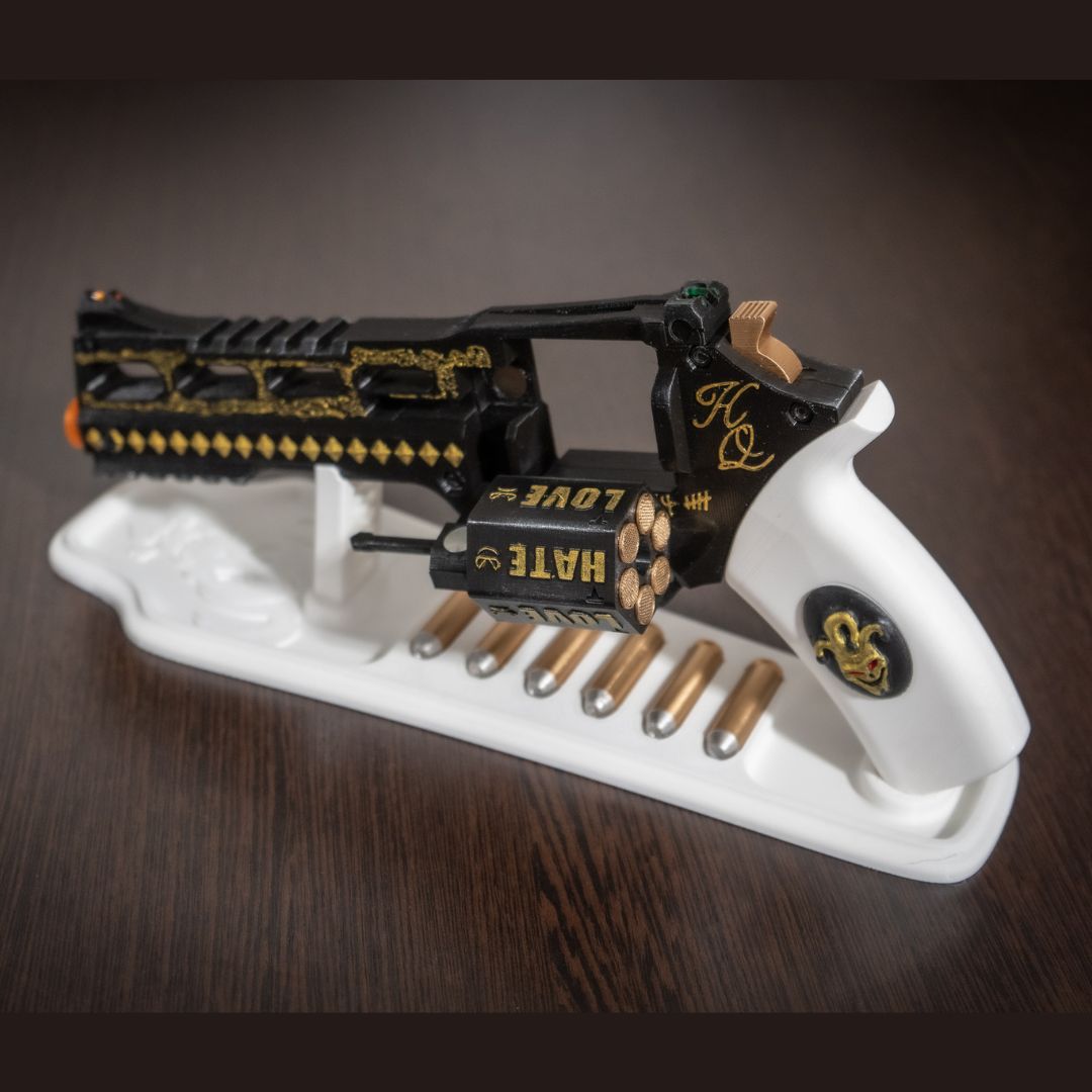 Harley Quinn's Revolver 3D printed movie-accurate cosplay prop with white stand and bullets.