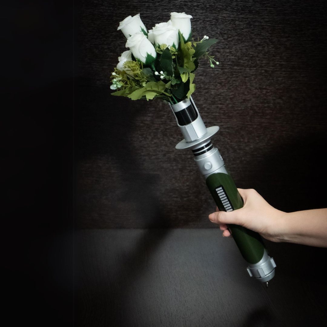Star Wars inspired bridal bouquet holder shaped like Kanan Jarrus lightsaber with white roses and greenery
