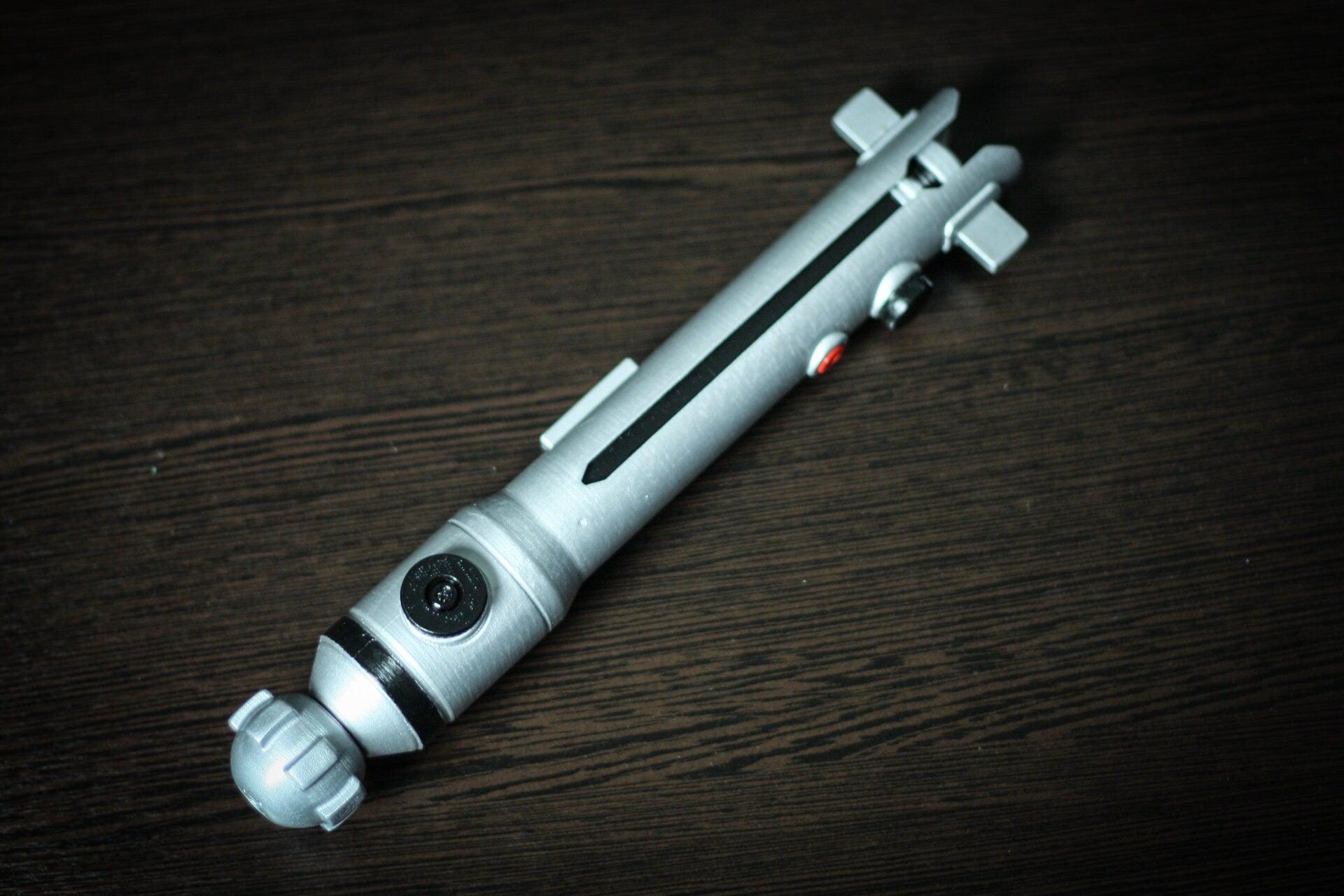 Ahsoka Tano lightsaber replica Star Wars cosplay prop in silver plastic with detailed buttons and design.