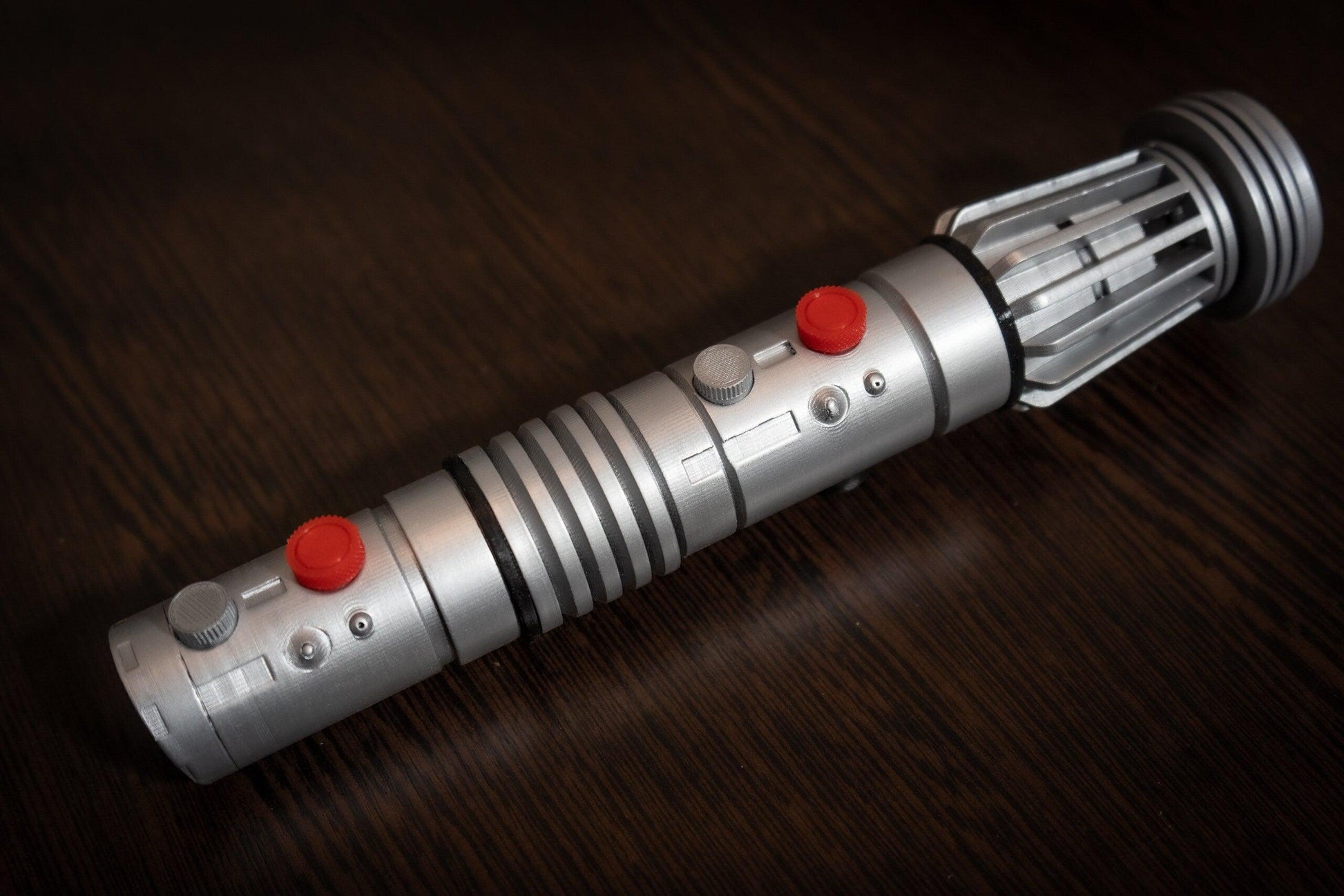 Darth Maul single-bladed lightsaber replica prop made of silver plastic with red and gray buttons for Star Wars cosplay and display.