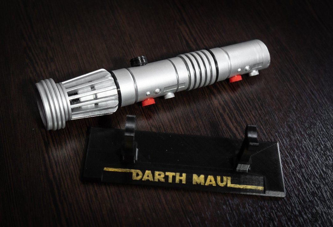 Darth Maul single-bladed lightsaber replica prop with display stand on dark surface