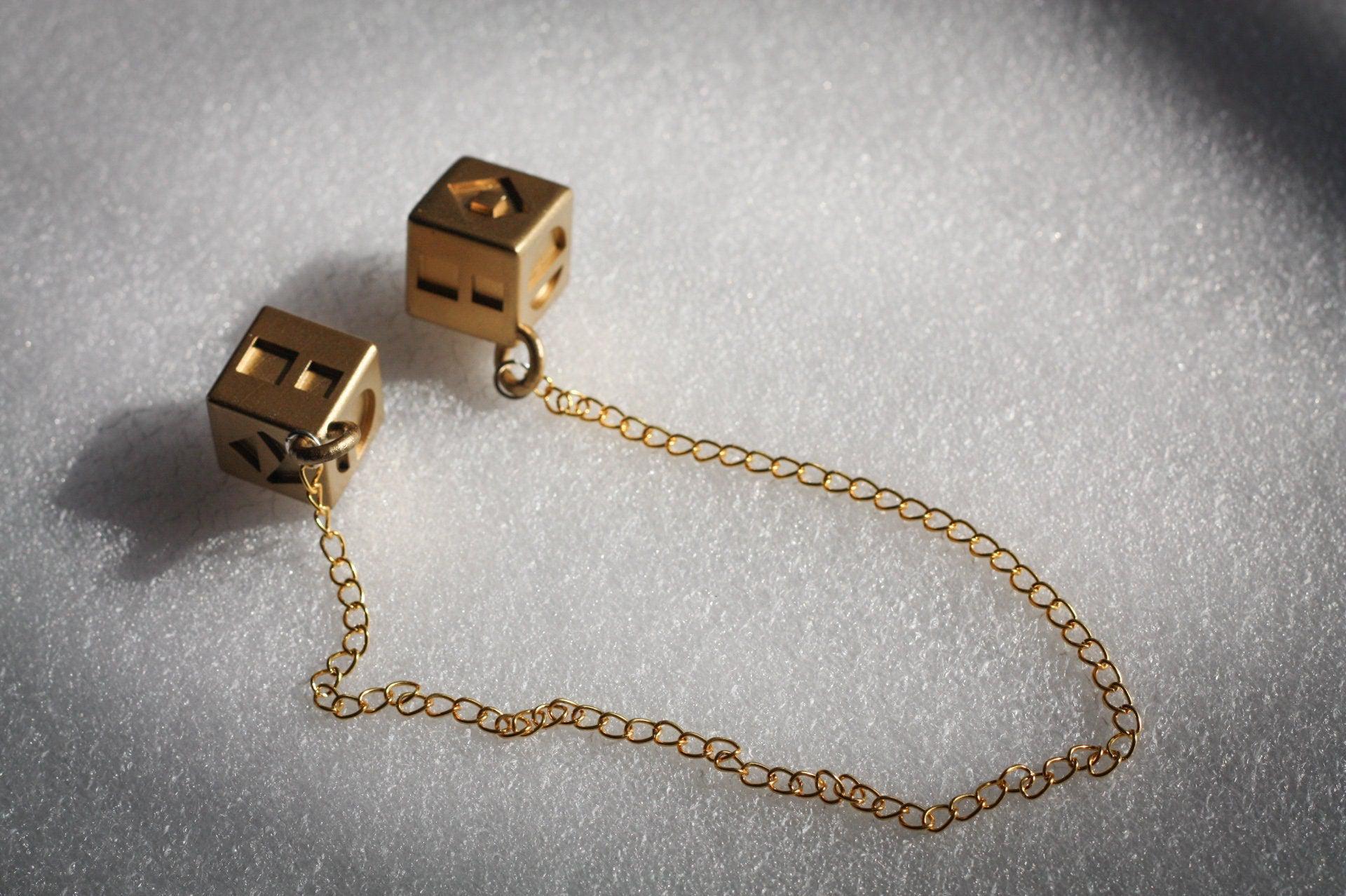 Han Solo's golden lucky dice replica with connecting gold chain for Star Wars cosplay and collectible display