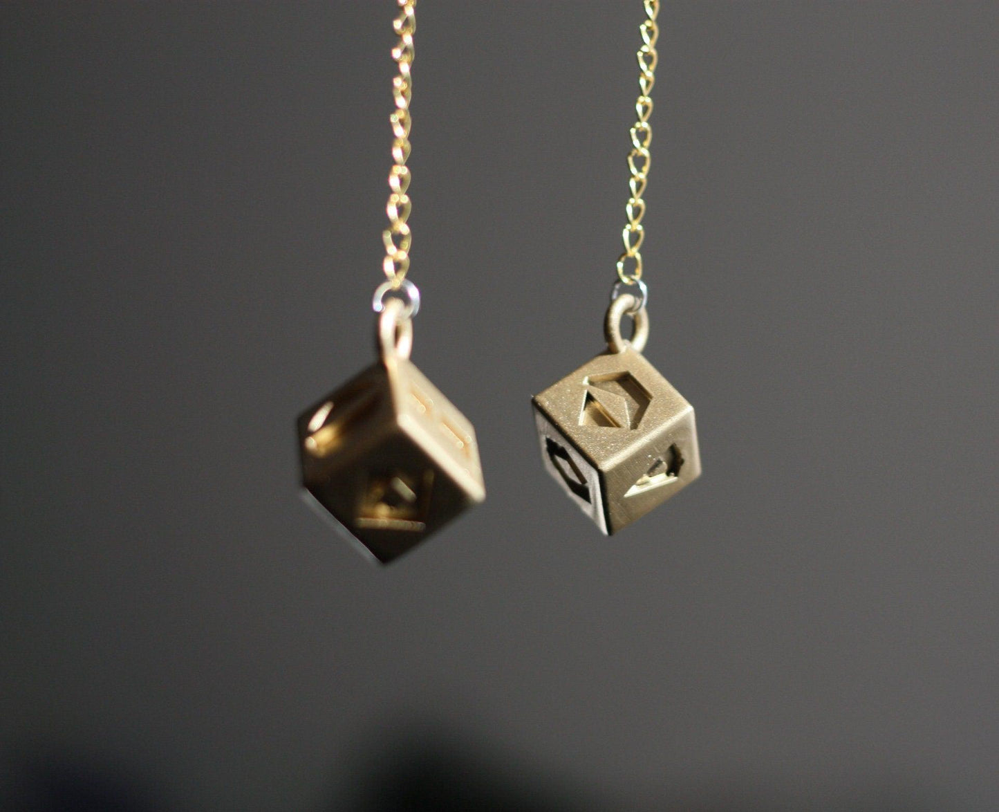 Han Solo's golden lucky dice replica hanging on gold chains for Star Wars cosplay accessory