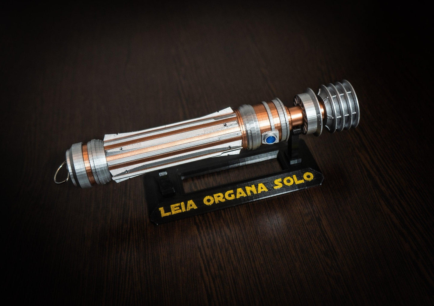 Replica of Leia Organa's lightsaber from Star Wars IX Rise of Skywalker displayed on a stand.