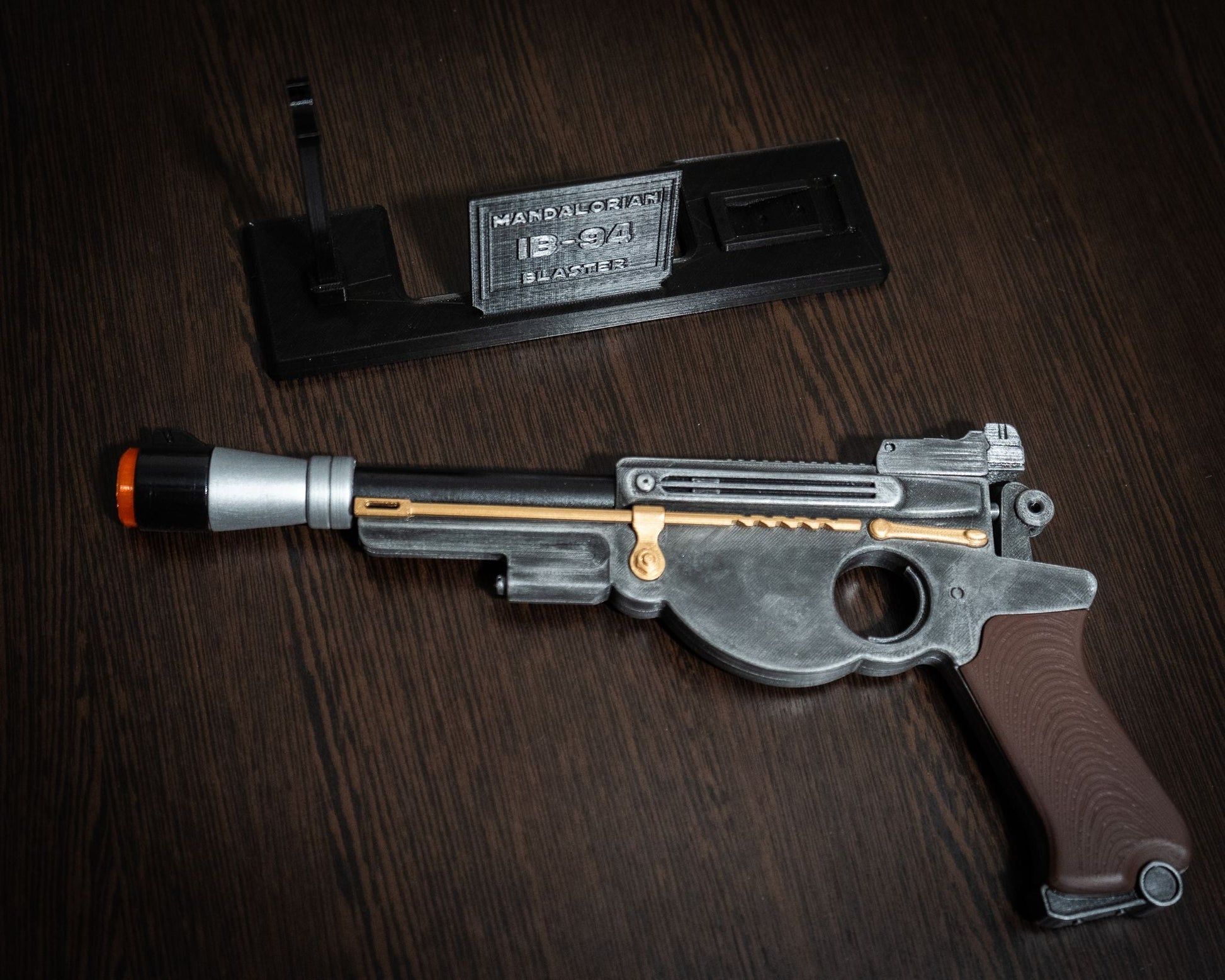 Mandalorian Blaster IB-94 Star Wars replica prop with display stand and orange safety tip for cosplay.