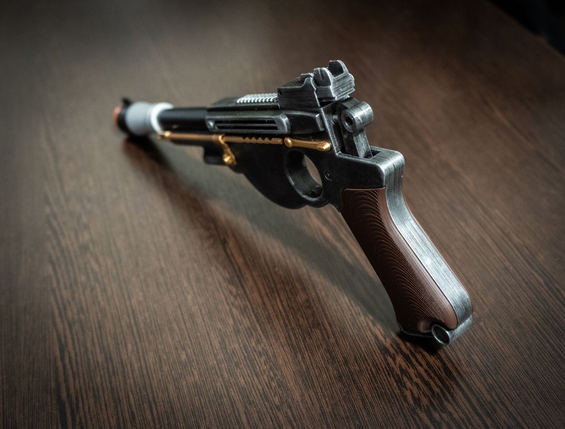 Mandalorian Blaster IB-94 Star Wars replica prop gun with black and brown handle on wooden surface