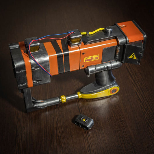 3D printed Fallout New Vegas AEP7 laser pistol cosplay prop with orange and black detailing and caution labels on dark wooden surface