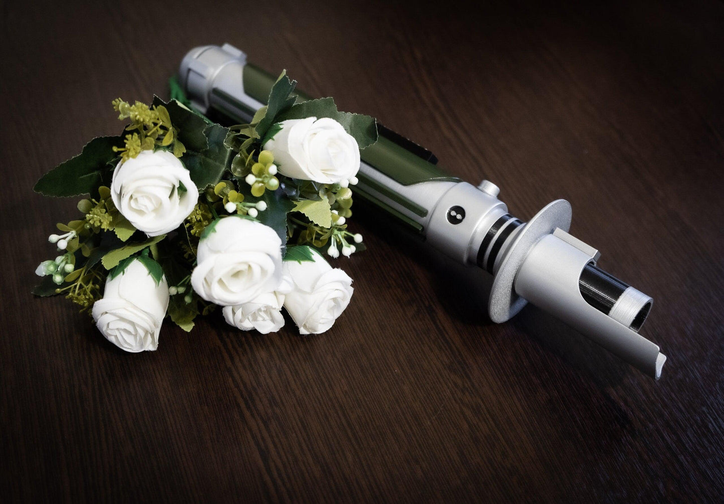Star Wars inspired bridal bouquet holder shaped like Kanan Jarrus lightsaber with white roses on wooden surface