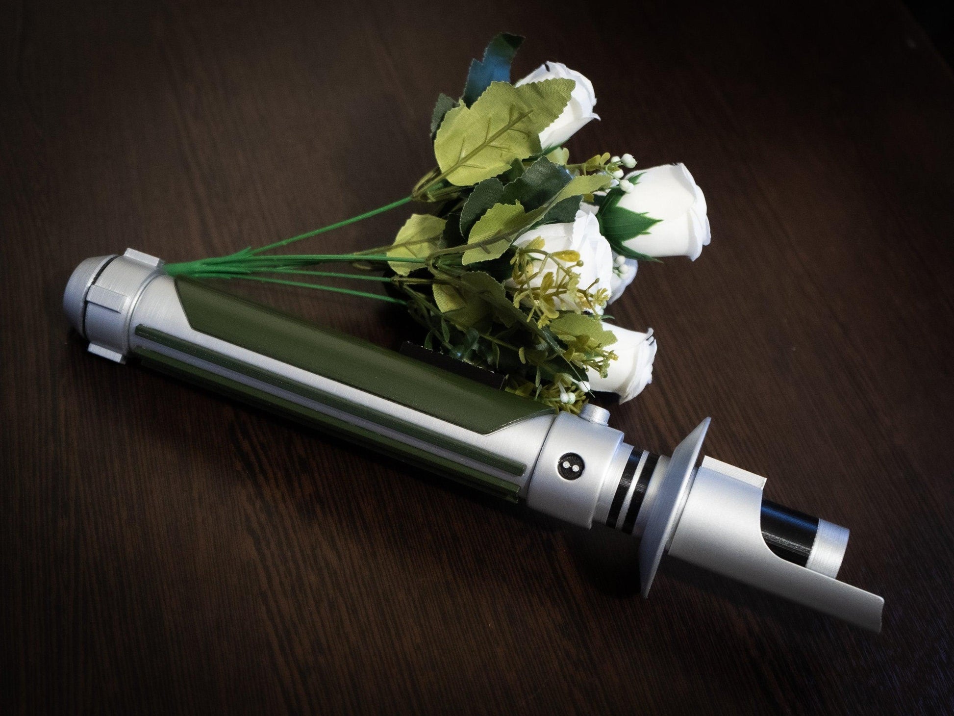 Star Wars inspired bridal bouquet holder shaped like Kanan Jarrus lightsaber with white flowers on wooden surface