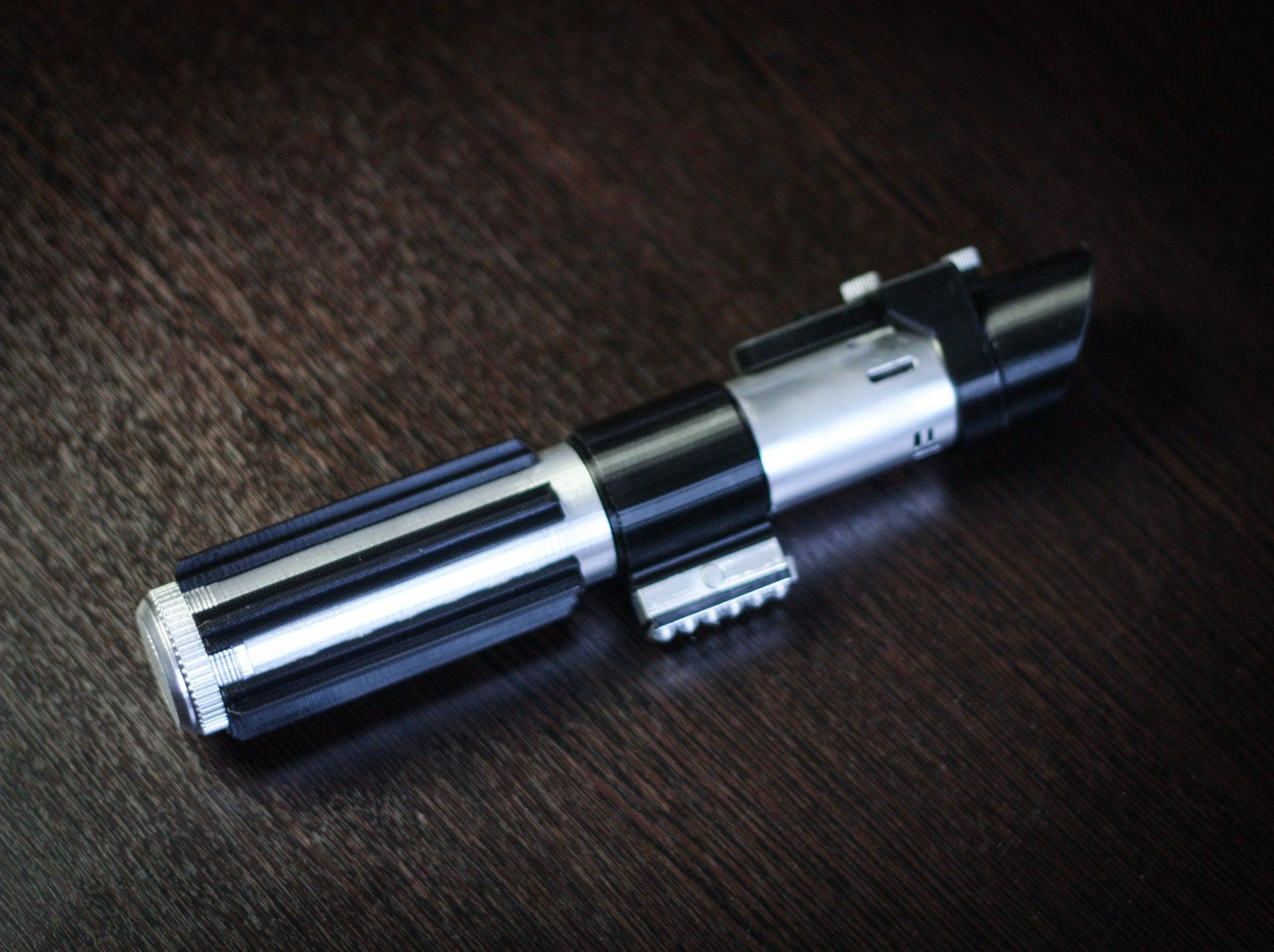 Star Wars inspired Darth Vader lightsaber bridal bouquet holder in black and silver on dark wood background