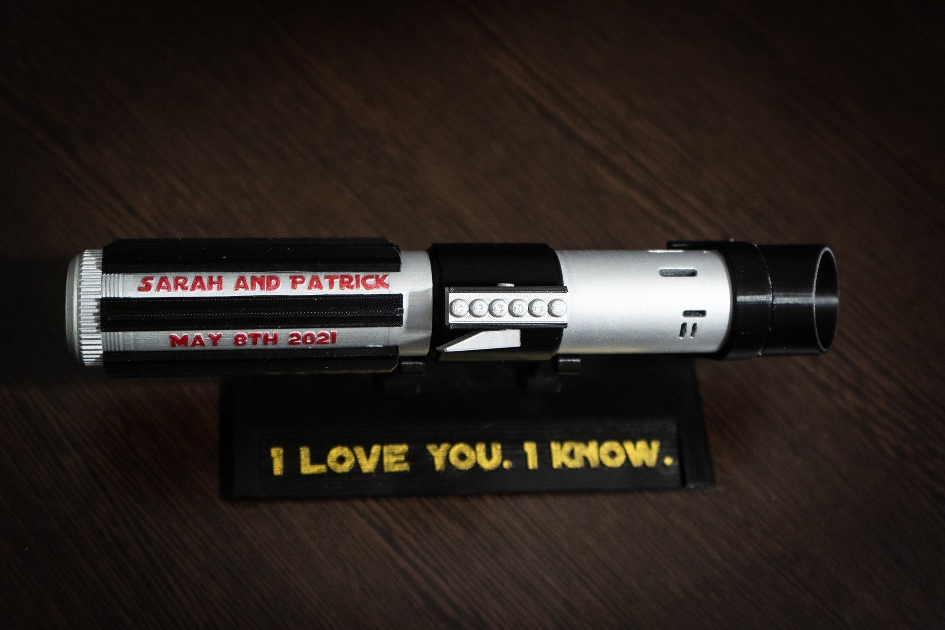 Personalized Star Wars inspired bridal bouquet holder shaped like Darth Vader's lightsaber with custom wedding date and names.