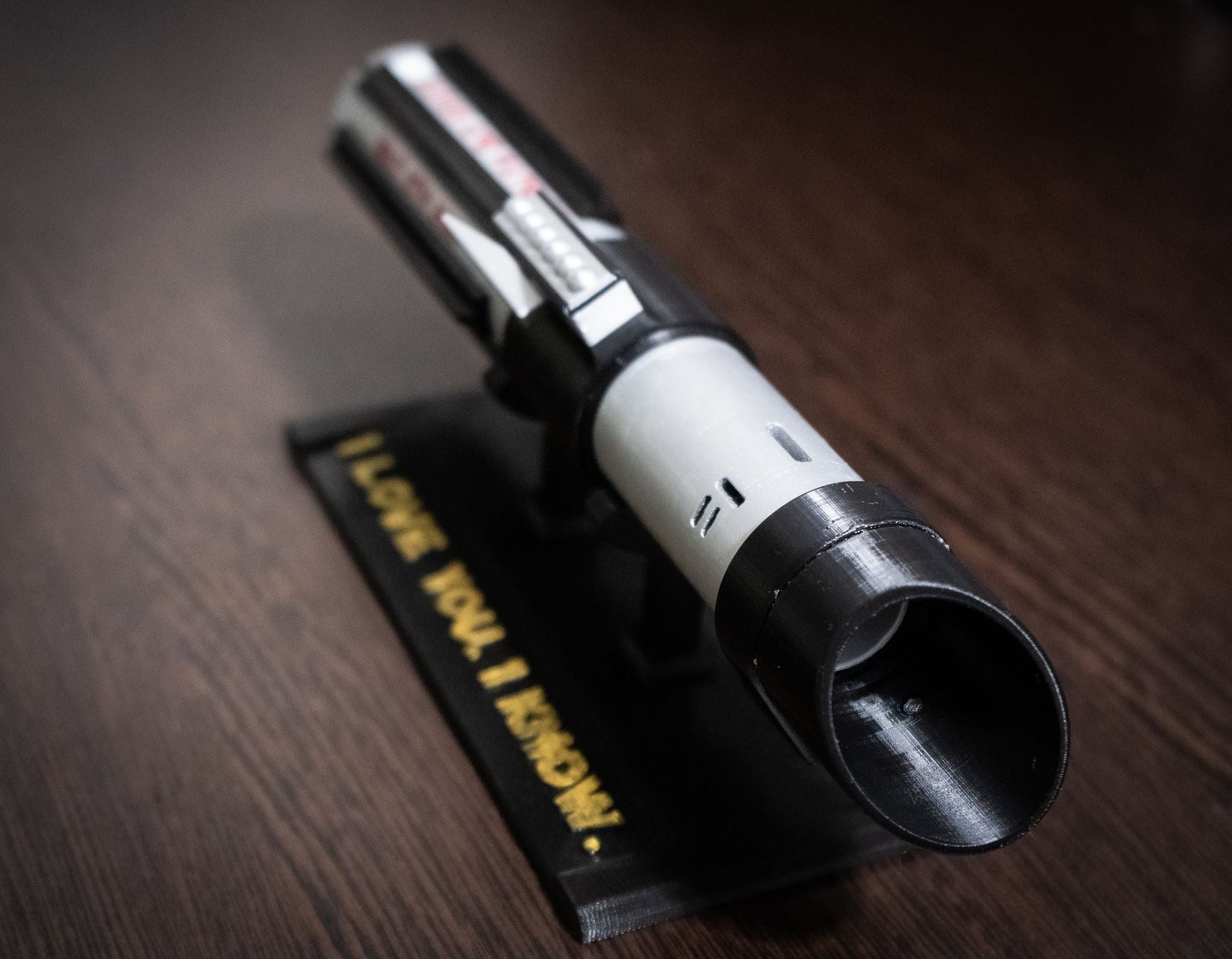 Black and grey Darth Vader lightsaber bridal bouquet holder with custom engraved base on wooden surface