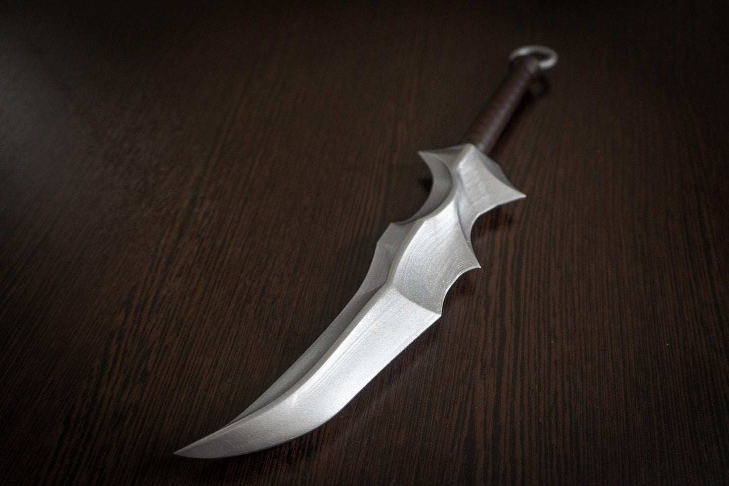 Vampire Blade cosplay prop replica inspired by Overlord with silver blade and brown handle on dark wooden surface