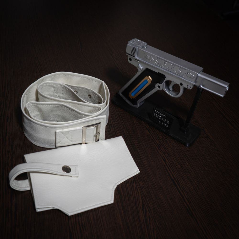 White belt, white pouch, and silver gun on a dark wooden surface