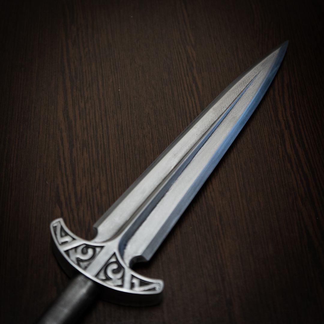 Decorative sword with an ornate handle on a wooden surface